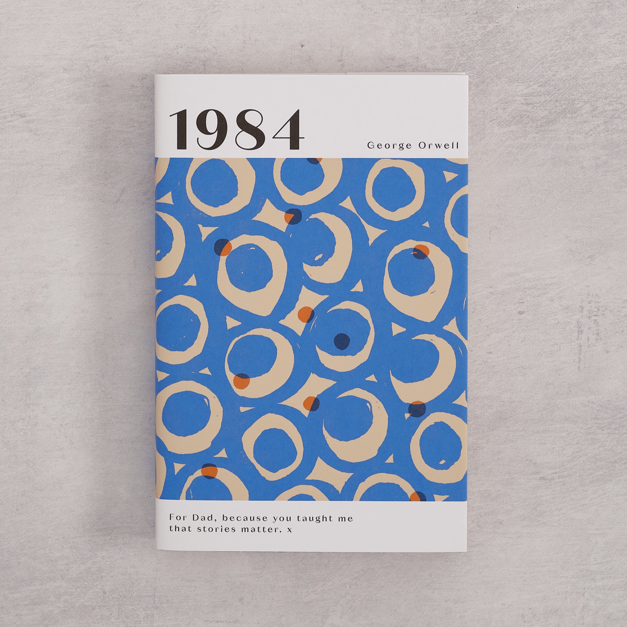 Bookishly edition of 1984 by George Orwell with a blue and cream patterned dust jacket and personalised message printed on the front cover.
