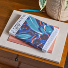 Book titled 'A Christmas Carol' on a wooden surface with a plant in the background