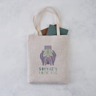 Personalised book bag tote with an upside down bat holding a book and the text “Sophie’s Book Bag” printed above.