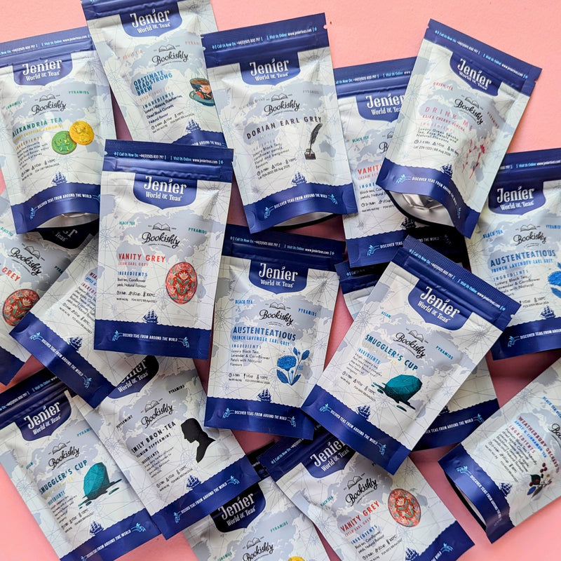 Assorted Bookishly literary teabag sachets inspired by classic books, scattered on a pink background.