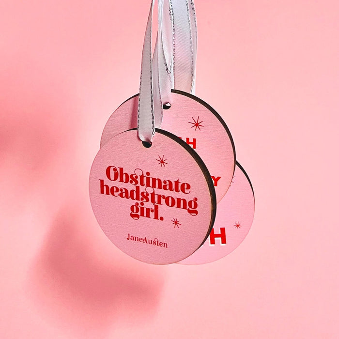 Bookish Christmas Tree decoration. Bright pink retro design. Colourful Christmas Tree Decor. Obstinate Headstrong Girl by Jane Austen. Perfect for book lovers, bookworms, bibliophiles and readers. Feminist festive hanging ornaments. 