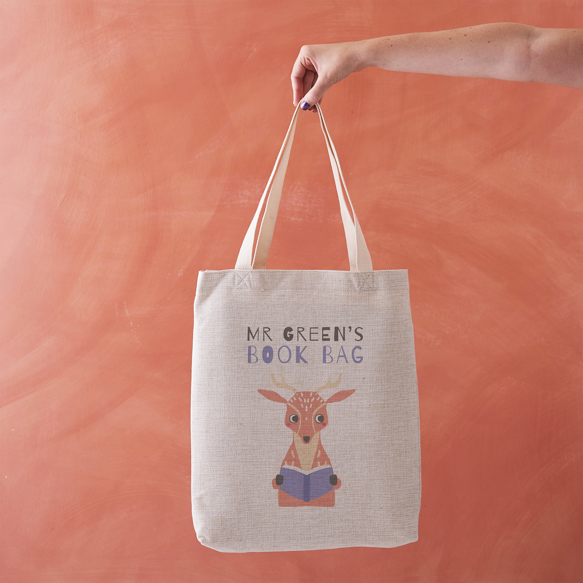 Tote bag with a deer illustration and 'MR GREEN'S BOOK BAG' text on a peach background