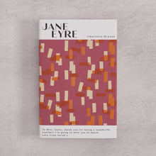 Bookishly edition of Jane Eyre by Charlotte Brontë with a pink and ochre patterned dust jacket and personalised message printed on the front cover.