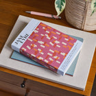 Book titled 'Jane Eyre' on a wooden surface with a plant in the background