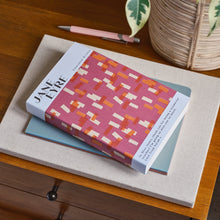 Book titled 'Jane Eyre' on a wooden surface with a plant in the background