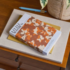 Book titled 'Little Women' on a wooden surface with a plant in the background