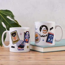 White ceramic mug with a colorful wrap-around collage of Halloween and bookish art.