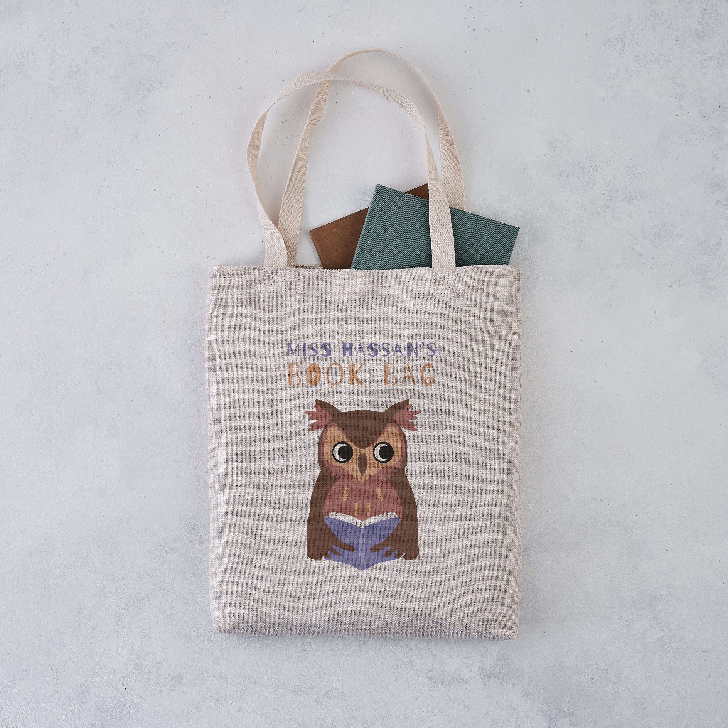 Tote bag with owl design and text on a light gray background