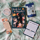Book titled 'Pride and Prejudice' with a bookmark, sticker, and card on a patterned surface