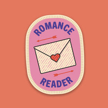 “Romance Reader” sticker in the style of a pink stitched merit badge, featuring a love letter design on a soft pink background.
