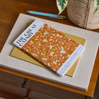 The Great Gatsby book on a wooden surface with a plant in the background