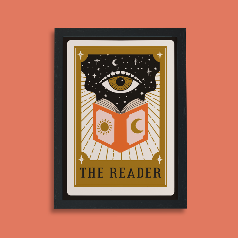 Framed art print with tarot card design showing an eye above an open book with sun and moon symbols, titled “The Reader.”