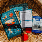 Books and a tea bag on a woven basket with a patterned background