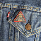 True Crime Reader wooden pin attached to the pocket of a denim jacket.