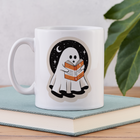 Close-up of ghost reading mug placed on top of a book.