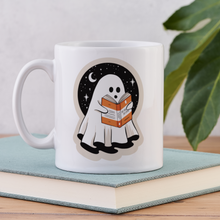 Close-up of ghost reading mug placed on top of a book.