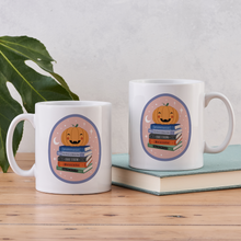 Two white mugs with pumpkin and book stack design featuring Dracula, Frankenstein, and other spooky classics.