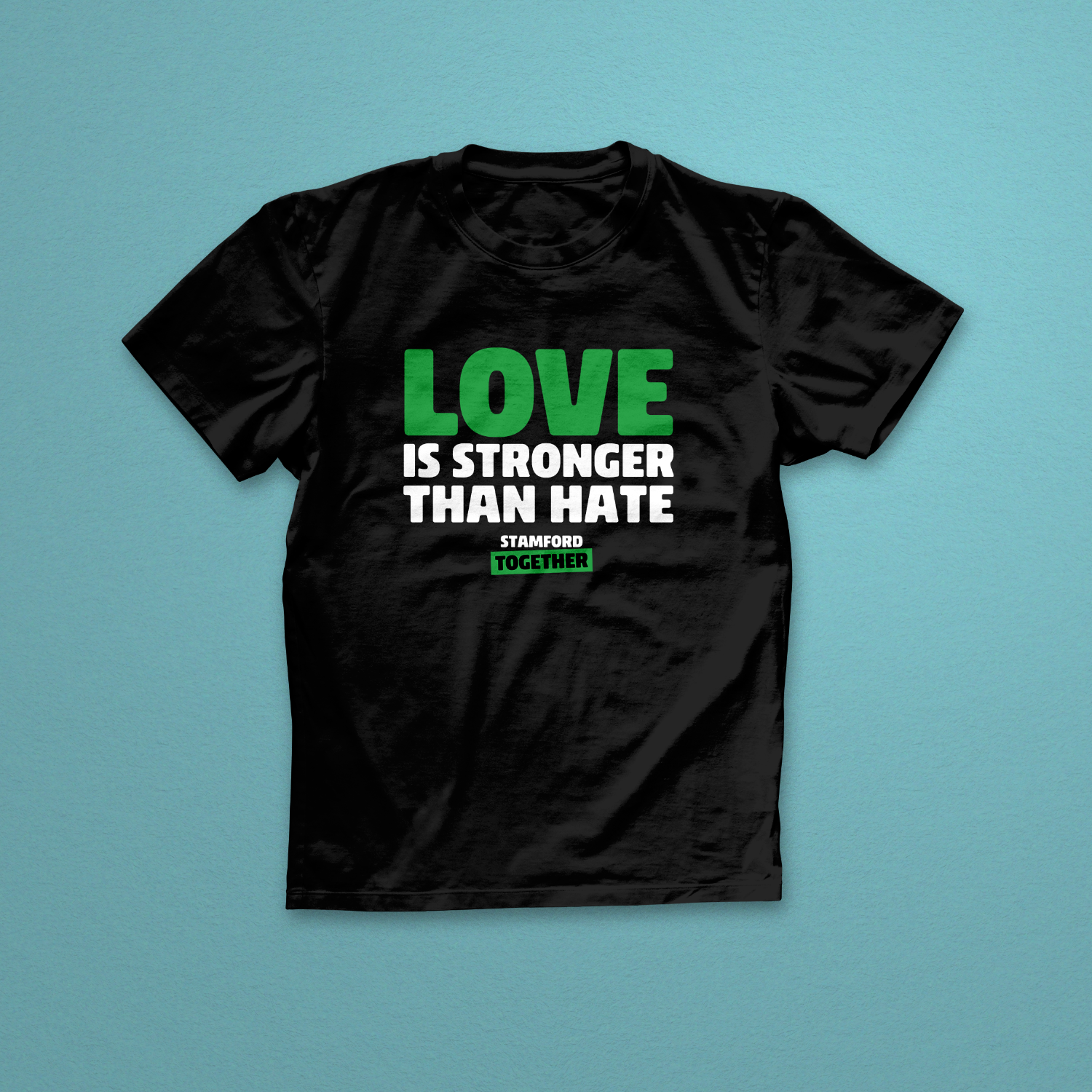 Black t-shirt with 'Love is Stronger Than Hate' text on a blue background