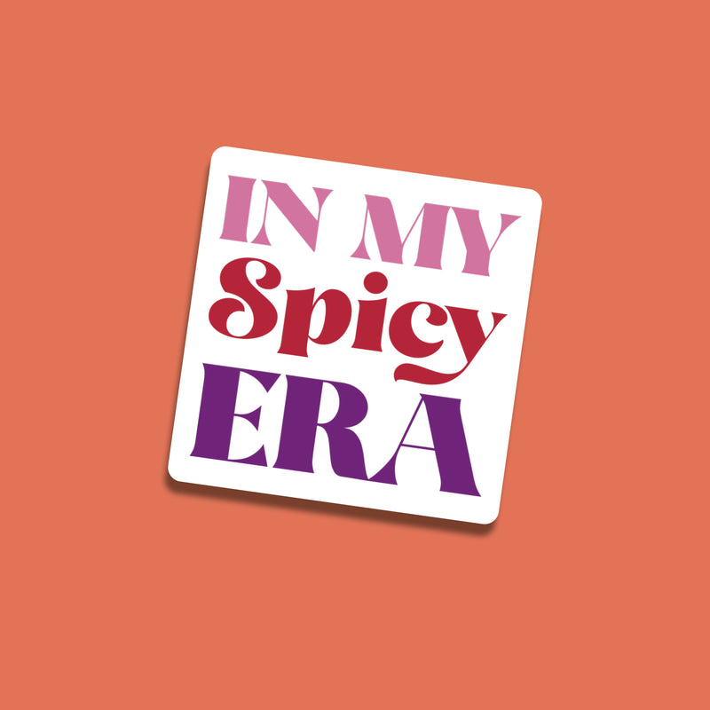 Square sticker reading “In My Spicy Era” in bold pink, red, and purple lettering on a coral background.