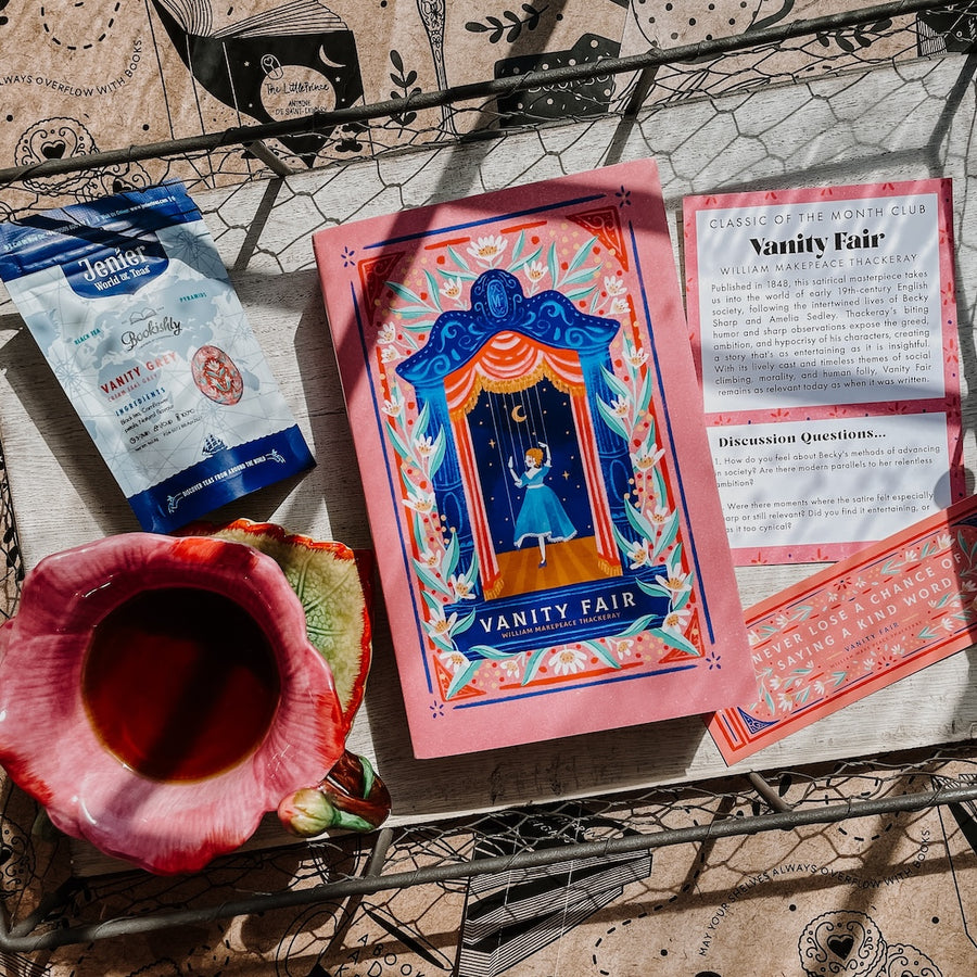 Vanity Fair book and tea packaging with a cup of tea on a decorative surface