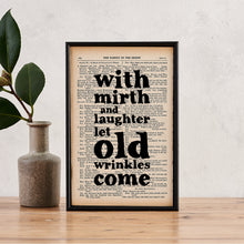 Framed book page print with the quote “With mirth and laughter let old wrinkles come” printed in bold black type onto a page from The Complete Works of William Shakespeare.