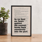 Framed book page print with the quote “So we beat on, boats against the current, borne back ceaselessly into the past” from The Great Gatsby by F. Scott Fitzgerald